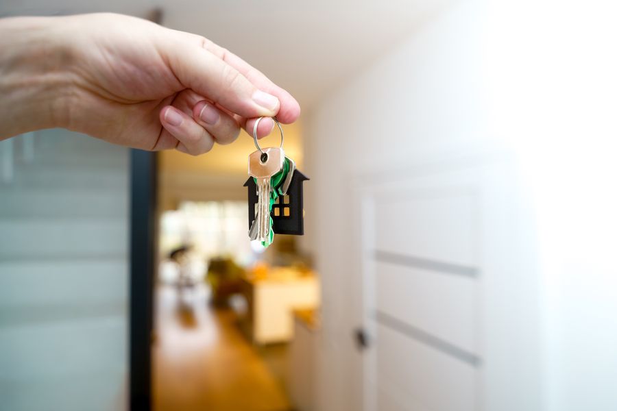 Hand met huissleutels in een licht appartement